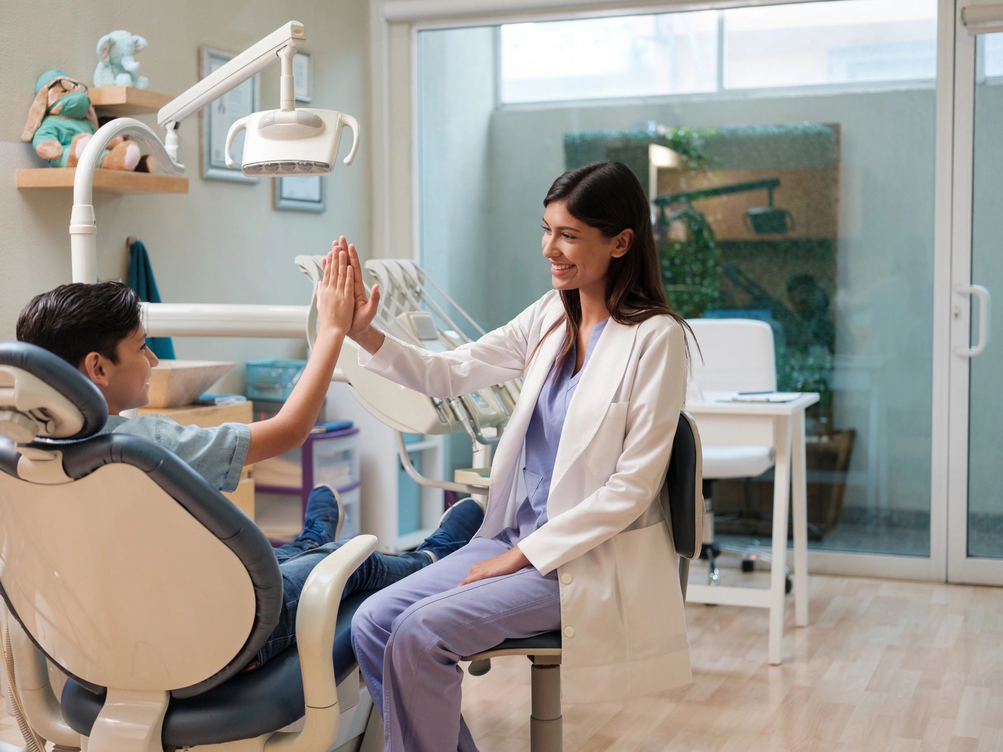Child patient smiling with dental assistant