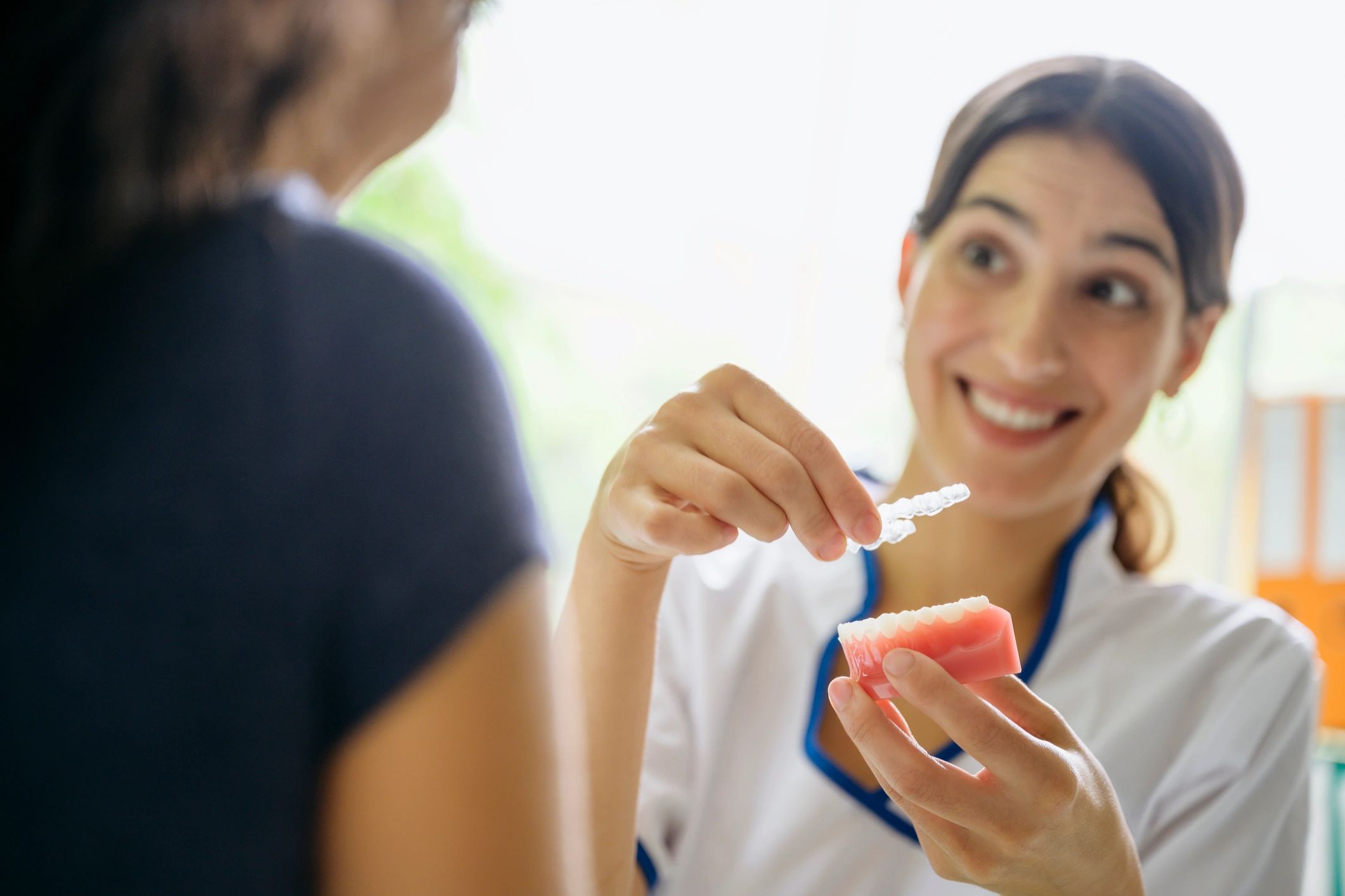 Dentist showing a transparent dental retainer to a patient