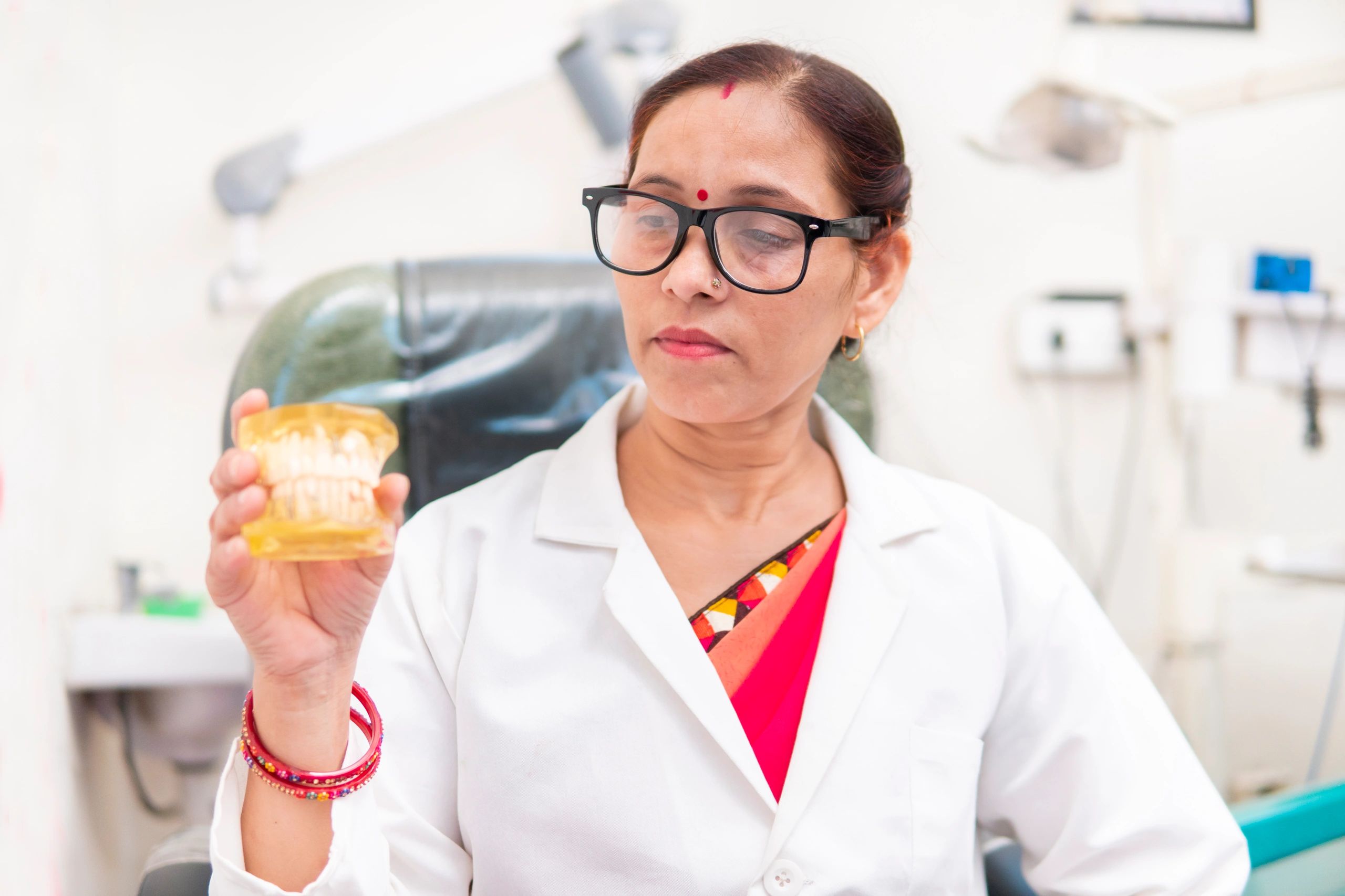Dental professional explaining aligner treatment with a teeth model